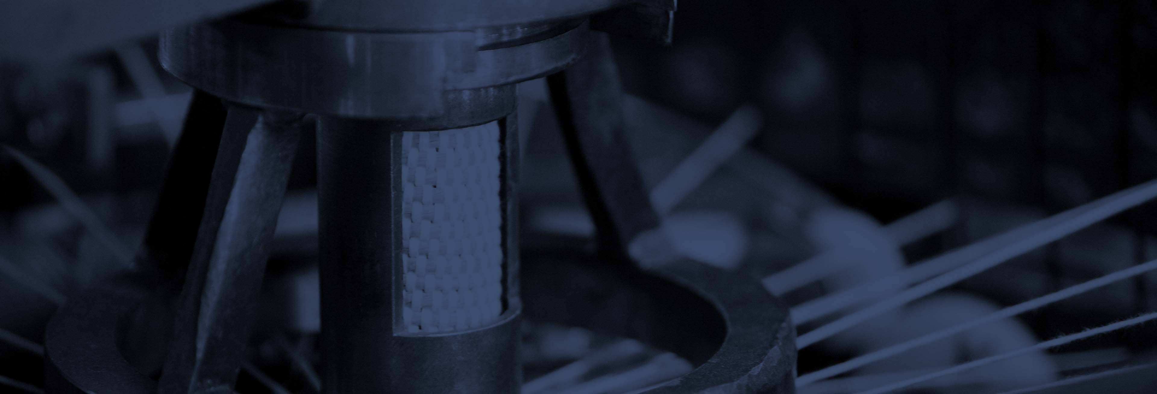 Saylor: Contact Us A dark blue tinted close up of a weaving loom head.